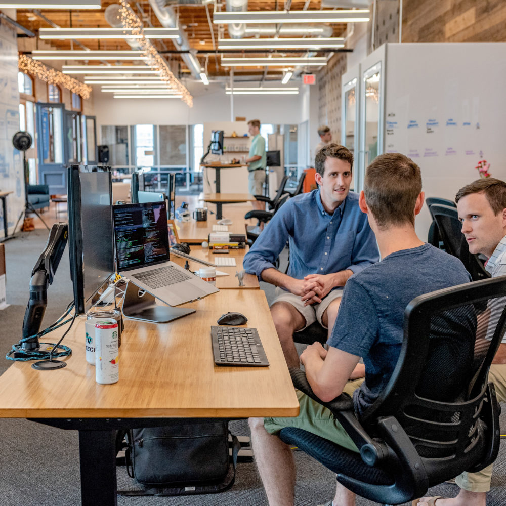 Men sitting at desk in conversation