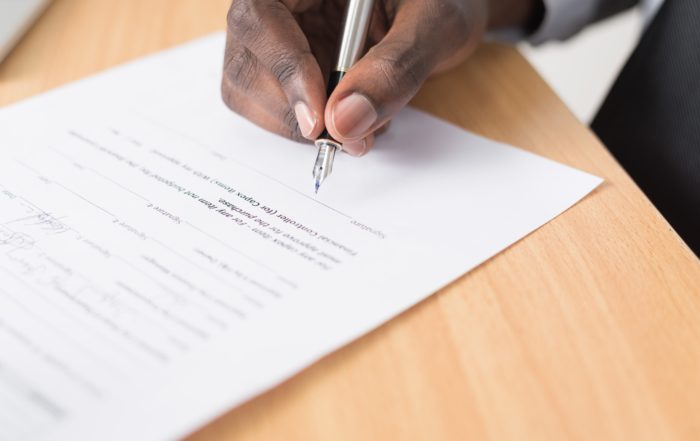 Person holding a pen signing a bonus
