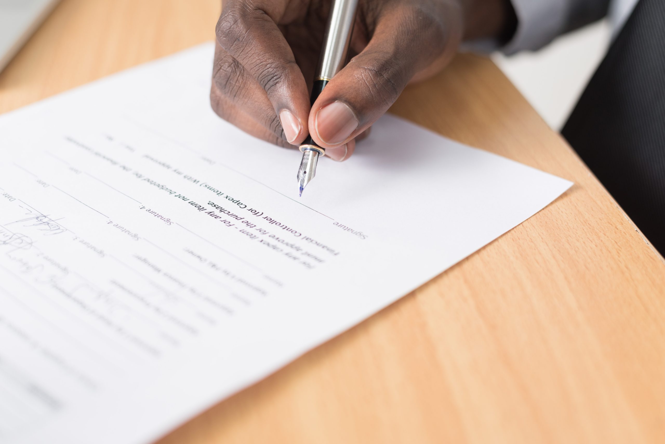 Person holding a pen signing a bonus