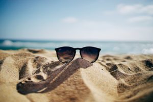 sunglasses on a beach submitting vacation requests