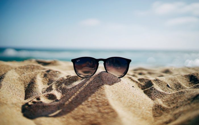 sunglasses on a beach submitting vacation requests